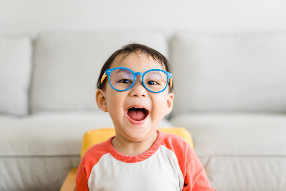 Toddler kid boy wearing glasses at home