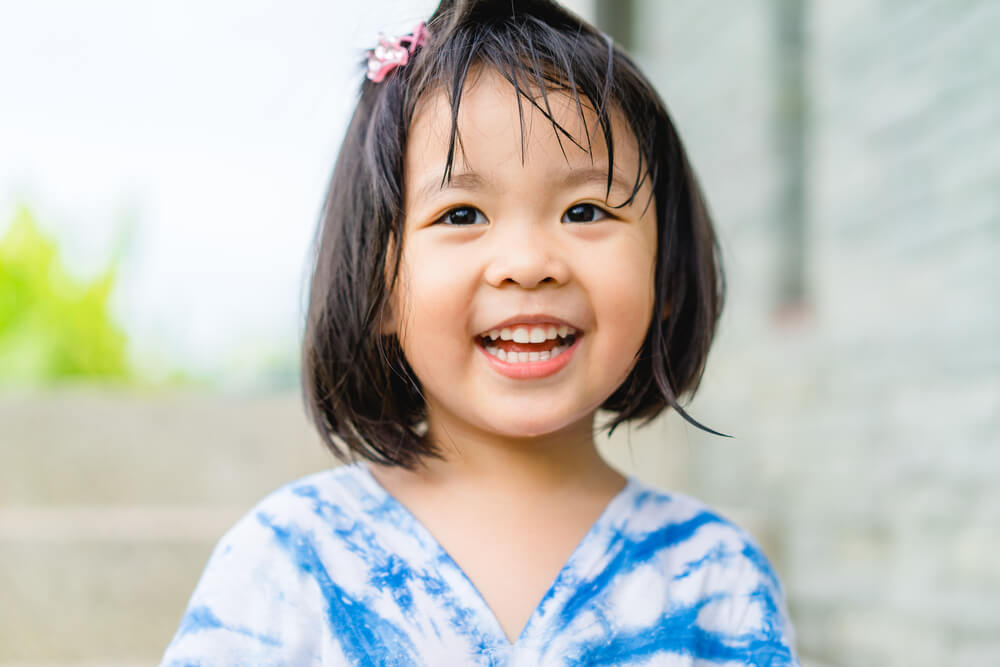 Little girl child showing front teeth with big smile